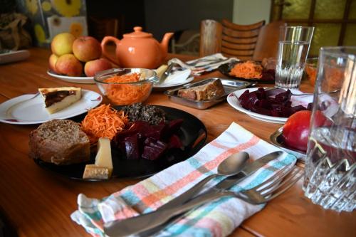 a wooden table with plates of food on it at Cottage des Moutons Espiègles in Saint-Martin-de-Nigelles
