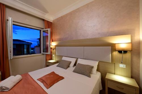 a bedroom with a large bed with a window at Pepe'Accommodation in Parghelia