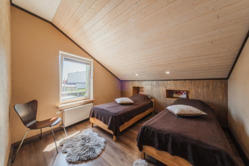 a bedroom with two beds and a window at Zaļais Stūrītis - Semi-Detached Holiday Home with Private entrance & Indoor Sauna in Liepāja