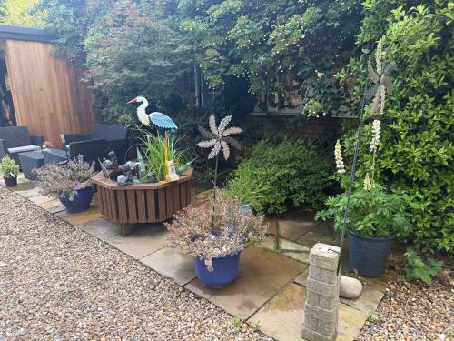 a garden with potted plants and a bird on a table at Da Vinci Guest House Gatwick Guest Parking, A Real Gem in Crawley