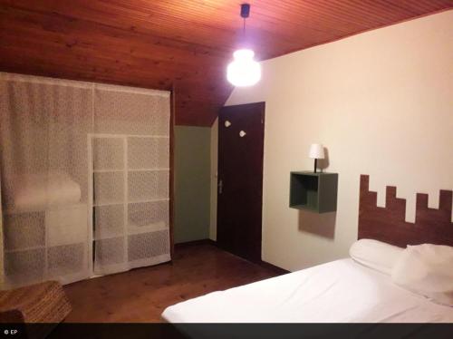 a bedroom with a white bed and a window at La maison de la Mouline in Arette
