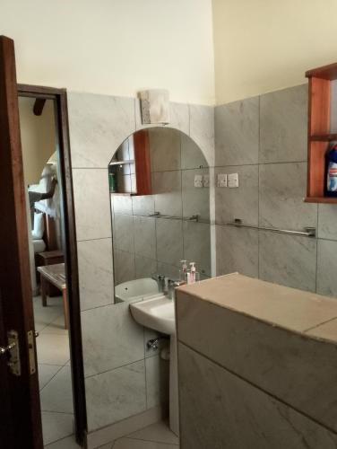 a bathroom with a sink and a mirror at Beach front Spacious Studio in Malindi