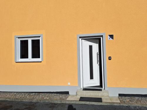 an orange building with a door and two windows at Kleinstadt-Fritz in Radeburg