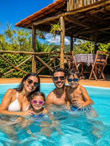 a family in the swimming pool at a resort at Pousada Estância Mineira in Guapé