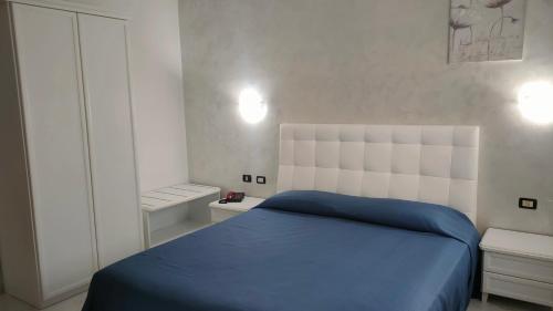a bedroom with a bed with a blue blanket at Grand Hotel Mosè in Villaggio Mosè