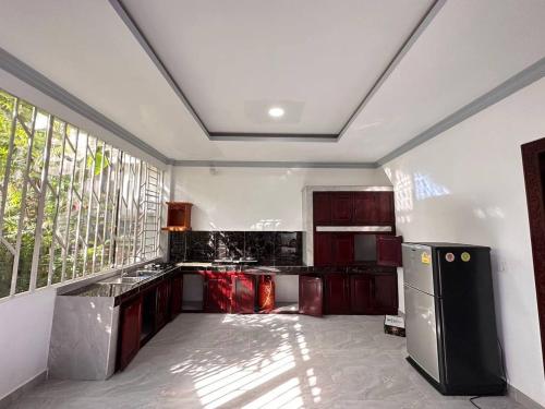 a kitchen with red cabinets and a large window at Suman Thapa House in Kathmandu