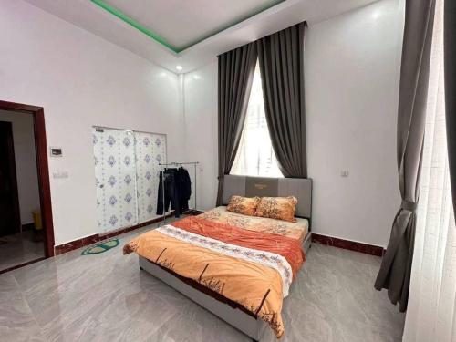 a bedroom with a bed with orange sheets and a window at Suman Thapa House in Kathmandu