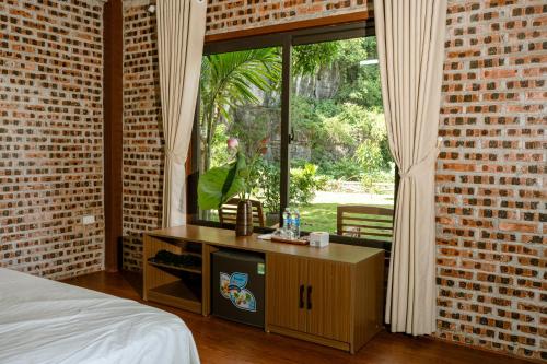 a bedroom with a bed and a brick wall at Tam Coc Aurora Valley in Vũ Lâm