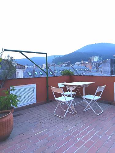 a patio with a table and chairs on a roof at Sobre la Ría 2 in Viveiro
