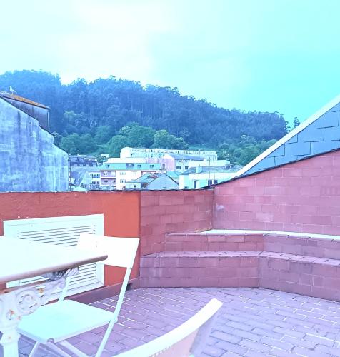 a patio with two chairs and a table and stairs at Sobre la Ría 2 in Viveiro