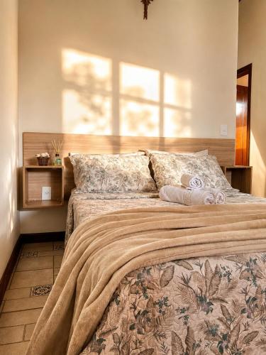 a bedroom with a large bed with a blanket on it at Pousada Estância Mineira in Guapé