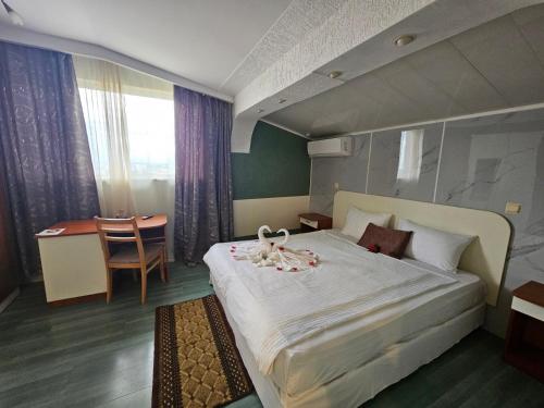 a hotel room with a large bed and a desk at Paralax Hotel in Varna City