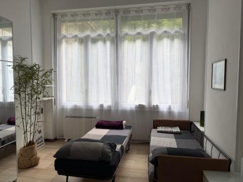 a room with two beds in front of a window at Appartamenti Lago di Como in Valbrona