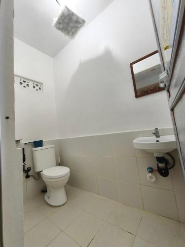 ein Badezimmer mit Toilette und Waschbecken in der Unterkunft Lagman Beachfront in Iba