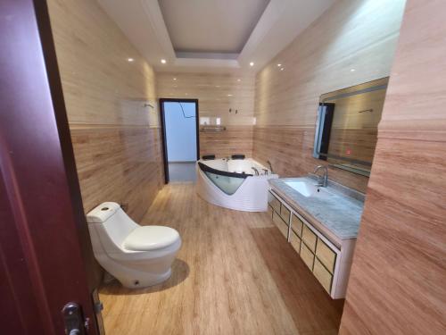a bathroom with a toilet and a sink and a tub at Cozy Almadies l'original in Dakar