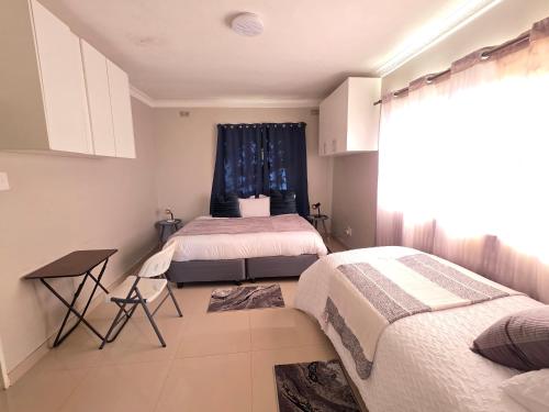 a bedroom with two beds and a window at Mutare Fairbridge Executive Suites in Umtali