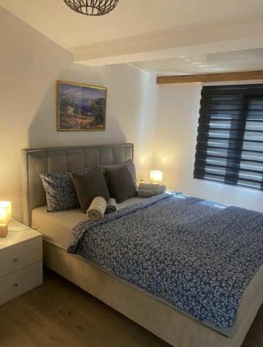 a bedroom with a large bed with two lamps and a window at Villa Klara in Gedići
