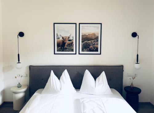 a bedroom with a bed with three pictures on the wall at Levio Homes Sunny Alpine Apartments with Balconies in Haus im Ennstal