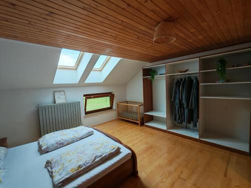 a large bedroom with a bed and a skylight at ZenHouseApartment in Ljubno