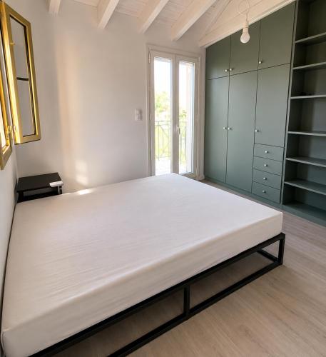 a large bed in a room with green cabinets at Valimitika beach house - Just 150m from the beach in Valimítika