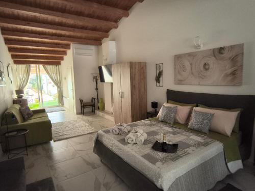 a bedroom with a large bed and a living room at THE KING'S LOFT Loft del Rè Sebi in Villasmundo