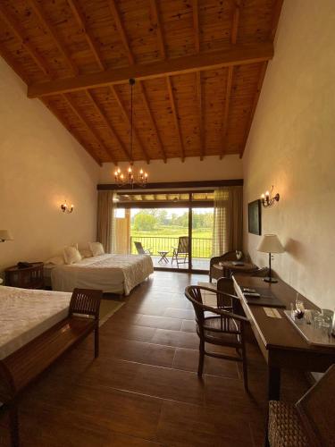 a bedroom with two beds and a table and chairs at San Ceferino Hotel & Spa in Open Door