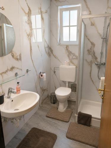 a bathroom with a sink and a toilet and a tub at Templer zum Gasthof in Lochenhaus
