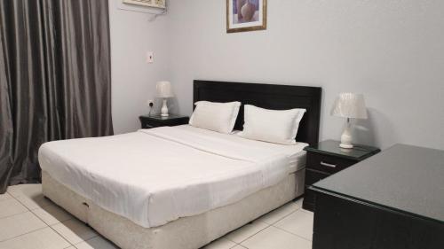 a bedroom with a bed with two night stands and two lamps at مساكن صفوه الديار in Abha
