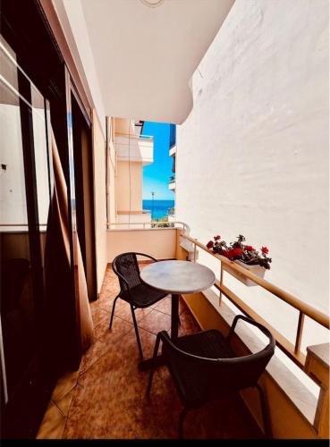 a balcony with a table and chairs and a window at Hotel Lungomare in Vlorë