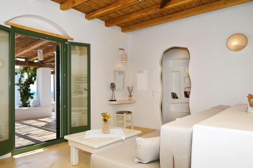 a white room with a bed and a table at Pambelos Lodge - Apartments in Koufonisia
