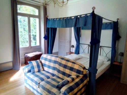 - une chambre avec un lit à baldaquin et un canapé dans l'établissement Chateau de la Raffe, à Naix-aux-Forges