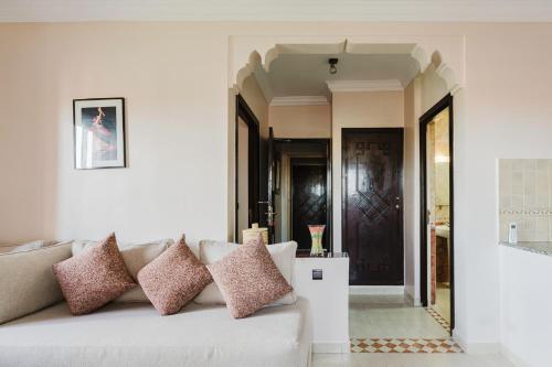 a living room with a couch with pillows on it at Amani Hotel Suites & Spa in Marrakesh
