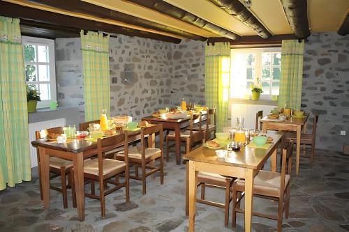 a dining room with wooden tables and chairs at La Maison De Suzanne in Arcomie