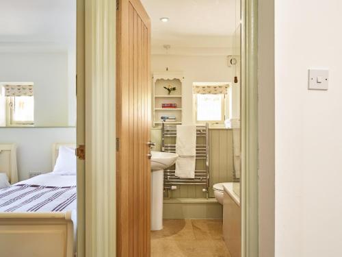 a small bathroom with a bed and a sink at Trevadlock Manor by Smart Welcomes in Launceston
