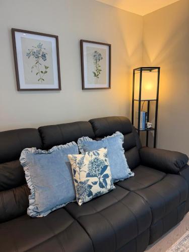 a brown couch with pillows in a living room at Number 1 School Path in Coalbrookdale