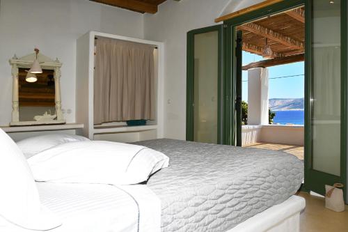 a bedroom with a bed and a view of the ocean at Pambelos Lodge - Apartments in Koufonisia