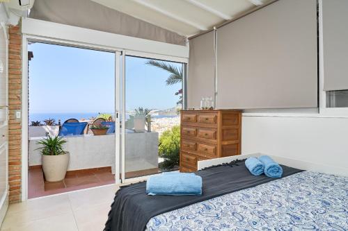 a bedroom with a bed and a view of the ocean at Casa Trino in Almuñécar