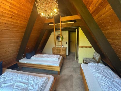 a attic bedroom with two beds and a chandelier at Ferienhaus Eichhörnchennest in Waldbrunn