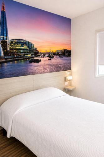 a bedroom with a large white bed and a city skyline at Hi! Monterrey Aeropuerto in Monterrey