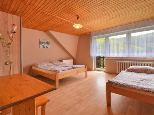 a large room with two beds and a window at Noclegi Pod Muńcołem in Ujsoły