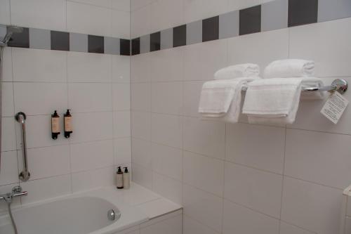 a bathroom with a tub and a sink and towels at Kasteel Wurfeld in Maaseik