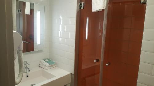 a bathroom with a shower and a sink and a mirror at ibis Styles Nimes Gare Centre in Nîmes