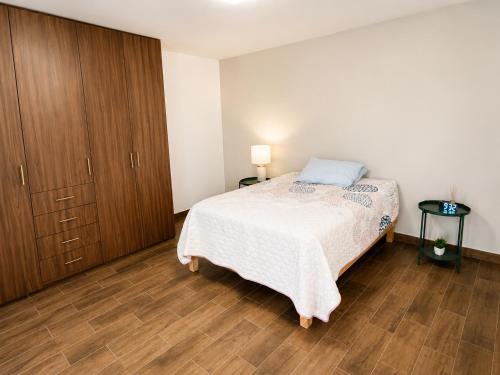 a bedroom with a bed and a wooden cabinet at Casa Cholula in La Concepción