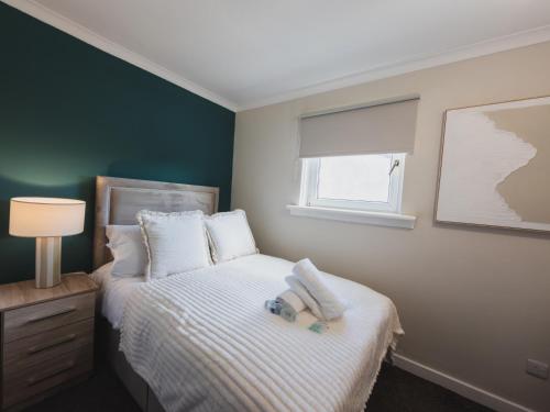 a bedroom with a bed and a window at The Cosy Plover in Johnstone