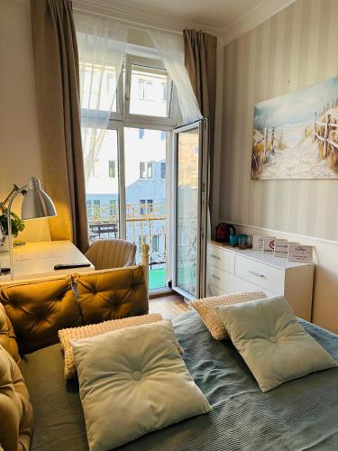 a living room with a couch and a large window at Dobry Adres in Gdynia