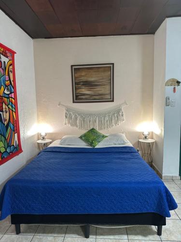 a bedroom with a bed with a blue bedspread at Charlys Place in San Salvador