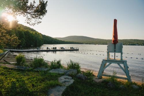 a lake with a wooden dock and a life preserver at Duchesnay - Sepaq in Sainte-Catherine