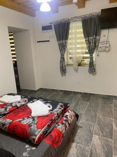 a bed sitting in a room with a window at Csillagfürt Vendégház in Kiskunmajsa