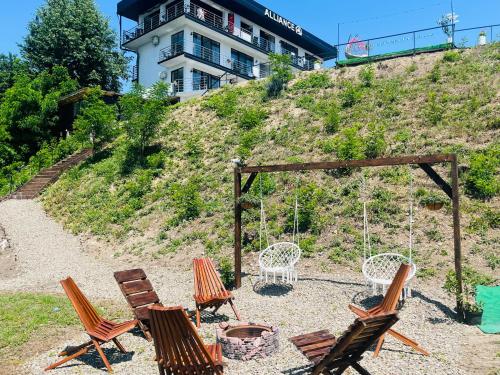 a group of chairs and a swing on a hill at ALLIANCE Hotel NEW 2025 -Breakfast and pool included in Solotvyno