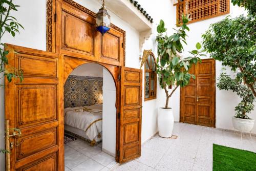 a bedroom with a wooden bed with an open door at Riad O LY in Marrakesh